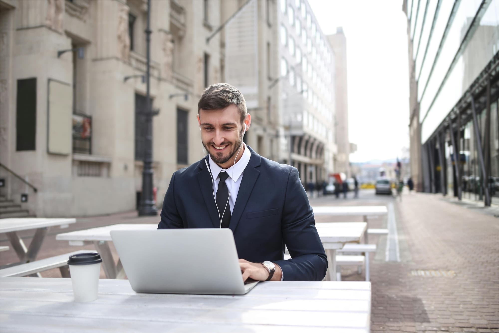 Man at outside desk with laptop on a call